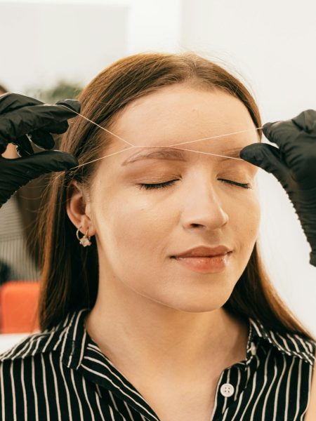 pexels photo 5177995 5177995 A woman receives precise eyebrow threading in a modern salon setting.